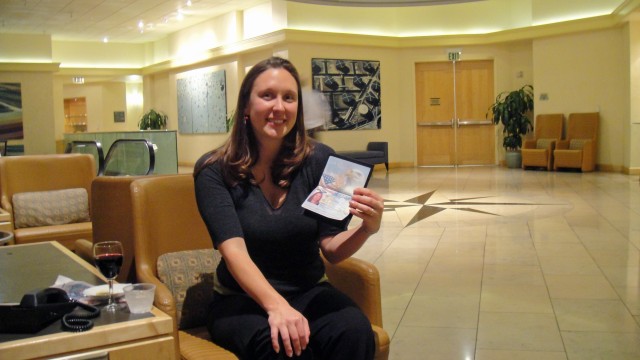 Kim in the Red Carpet Club at SFO, proudly displaying the new passport we managed to get in 4 hours the day of our departure.